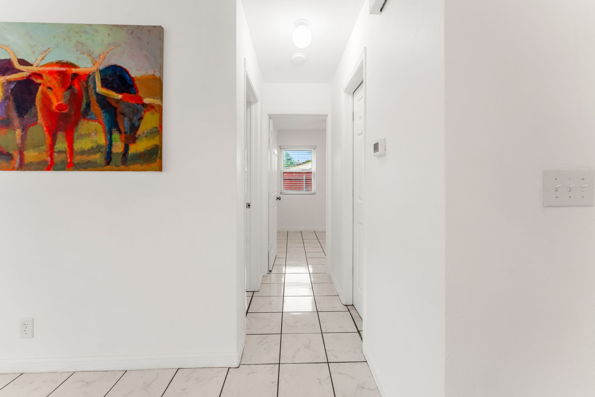 2501 Teri Road, Unit B Austin, TX 78744 - Photo 10 of 21 Hallway featuring white ceramic tile flooring with dark grout, white painted walls, and recessed lighting