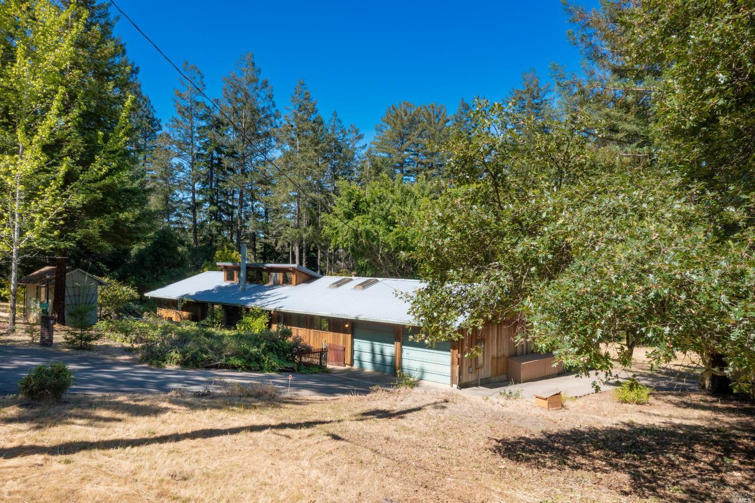 14377 Occidental Road Sebastopol, CA 95472 - Photo 1 of 1 a backyard of a house with table and chairs under an umbrella