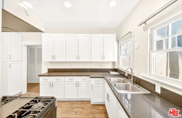 a kitchen with granite countertop a sink stove and cabinets