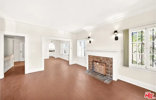 a view of a livingroom with wooden floor and a fireplace
