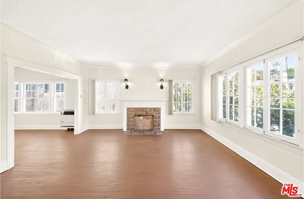 a view of an empty room with fireplace and a window