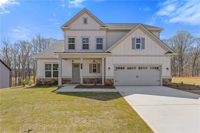 a front view of a house with a yard outdoor seating and garage