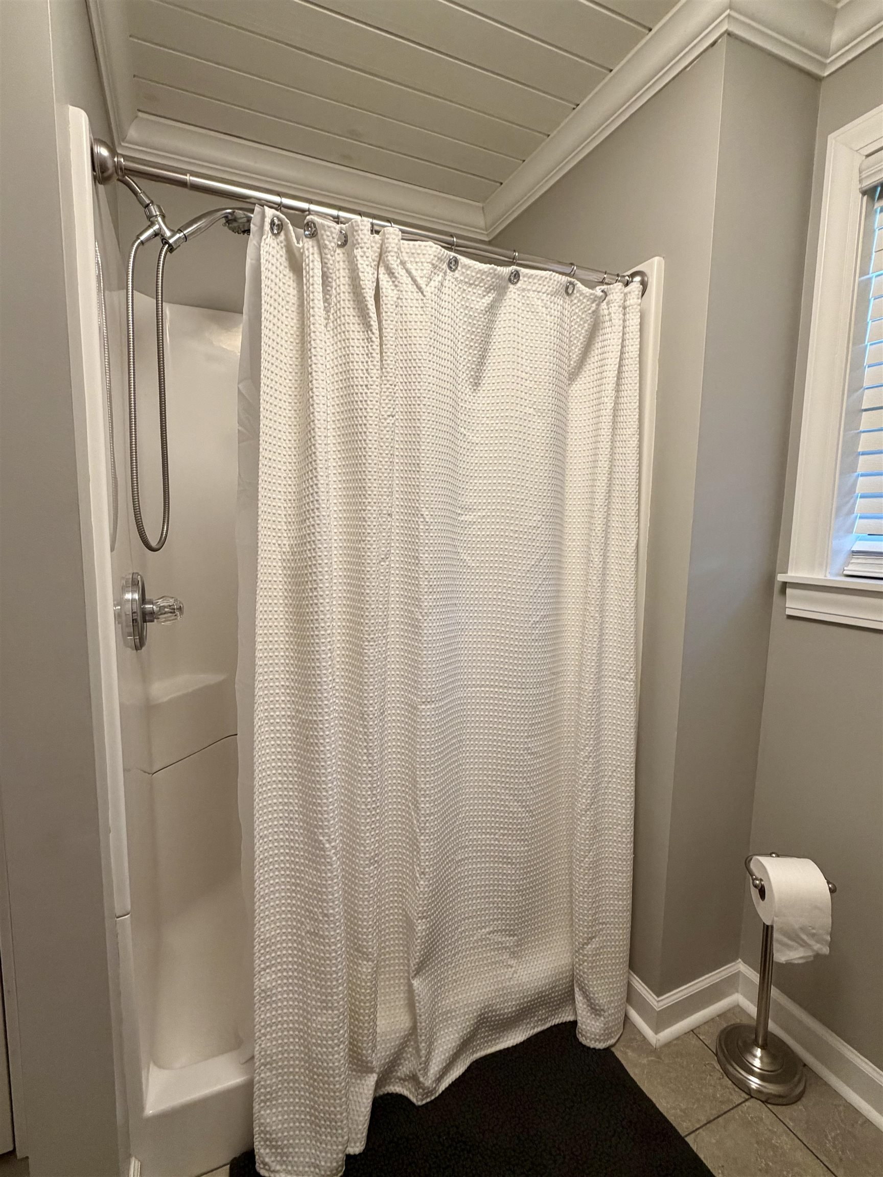 142 Treece Street Selmer, TN 38375 - Photo 14 of 36 Walk-in shower with a chrome shower head and handle, complemented by a white beadboard ceiling and crown molding