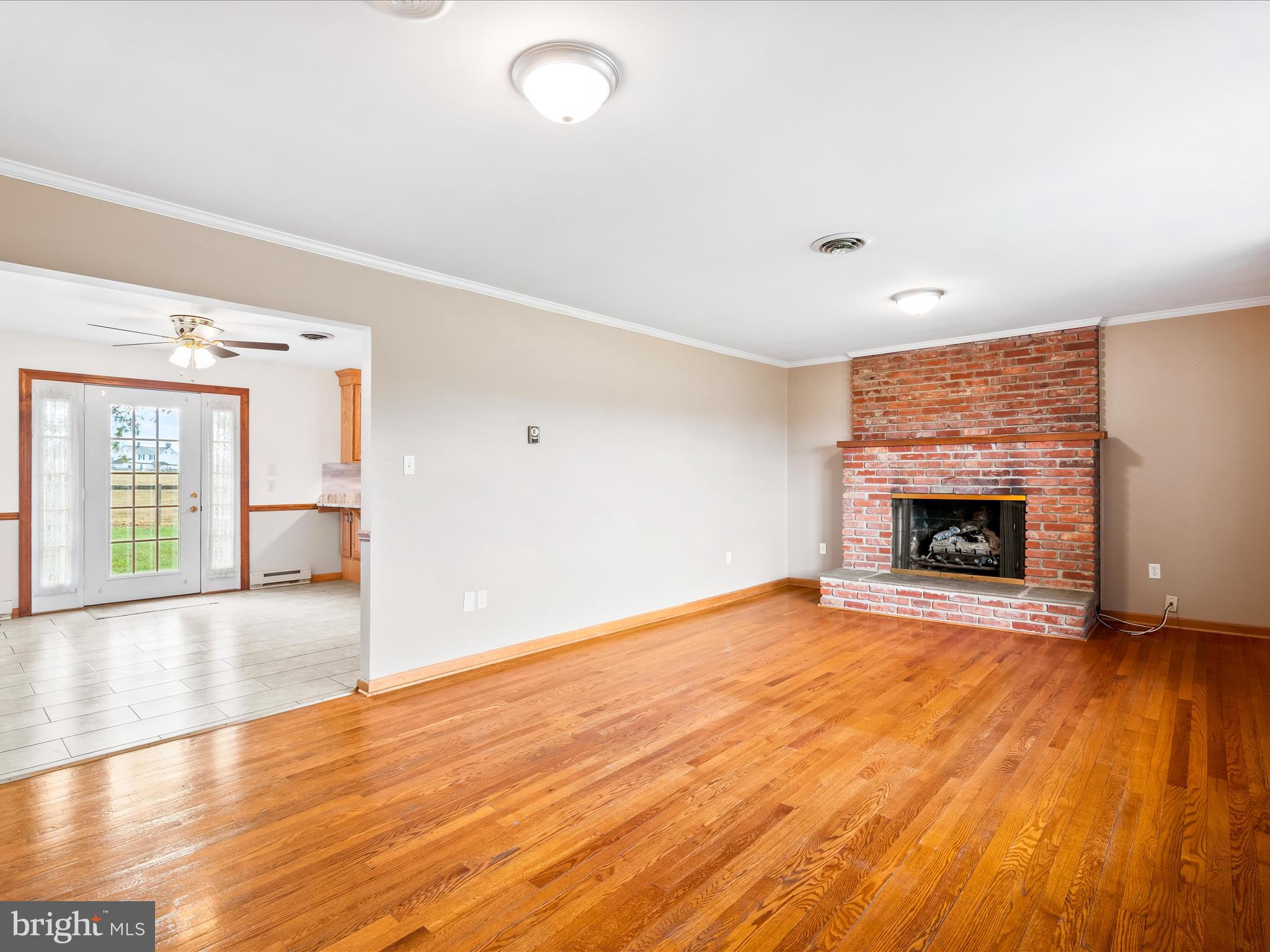 7429 Lewistown Road Thurmont, MD 21788 - Photo 13 of 68 an empty room with wooden floor and a fireplace