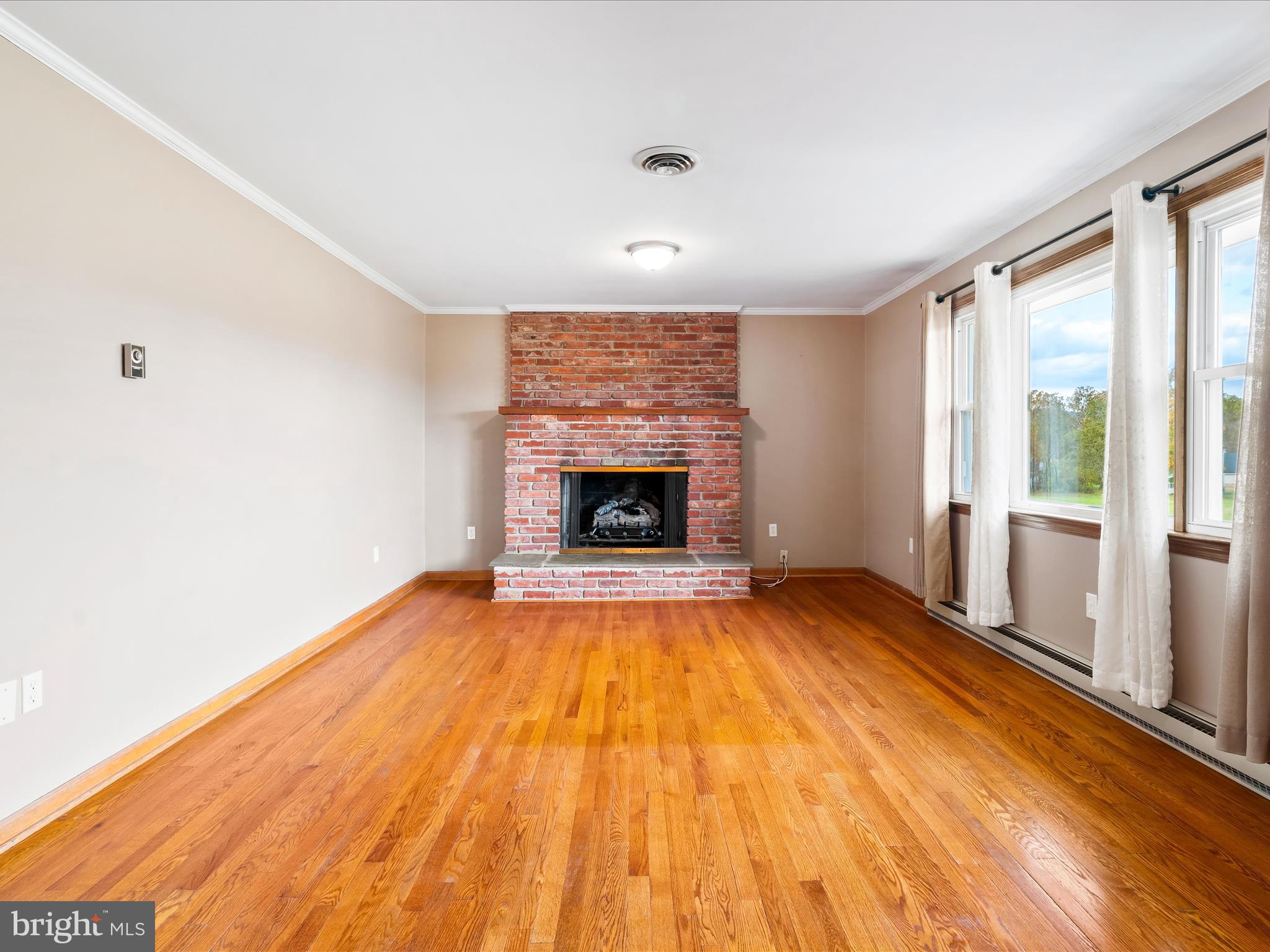 7429 Lewistown Road Thurmont, MD 21788 - Photo 14 of 68 a view of an empty room with a fireplace and a window