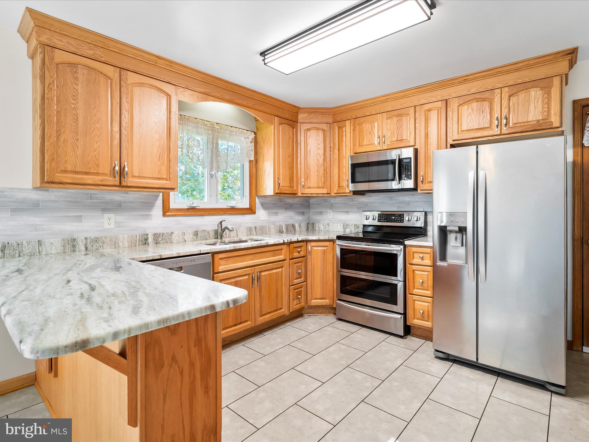 7429 Lewistown Road Thurmont, MD 21788 - Photo 15 of 68 a kitchen with stainless steel appliances granite countertop a refrigerator and a stove top oven