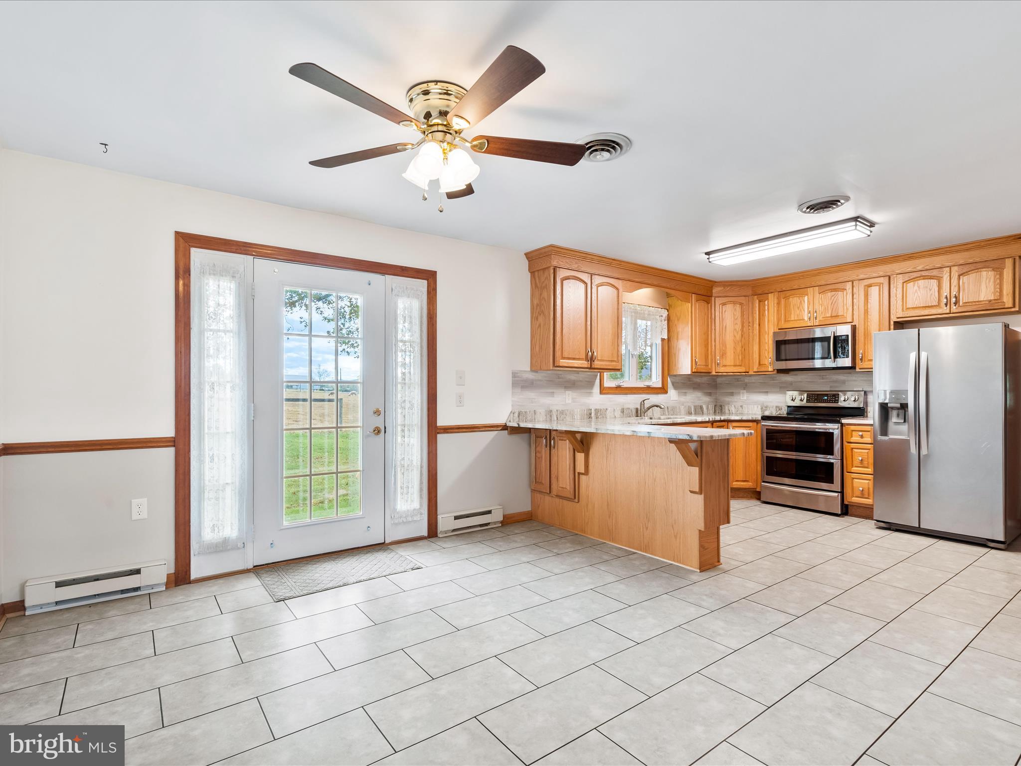 7429 Lewistown Road Thurmont, MD 21788 - Photo 17 of 68 a large kitchen with stainless steel appliances granite countertop a stove a sink and a refrigerator