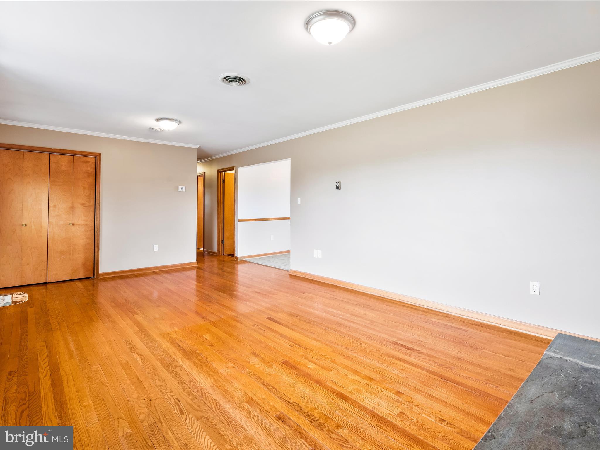 7429 Lewistown Road Thurmont, MD 21788 - Photo 20 of 68 an empty room with wooden floor and windows with curtains