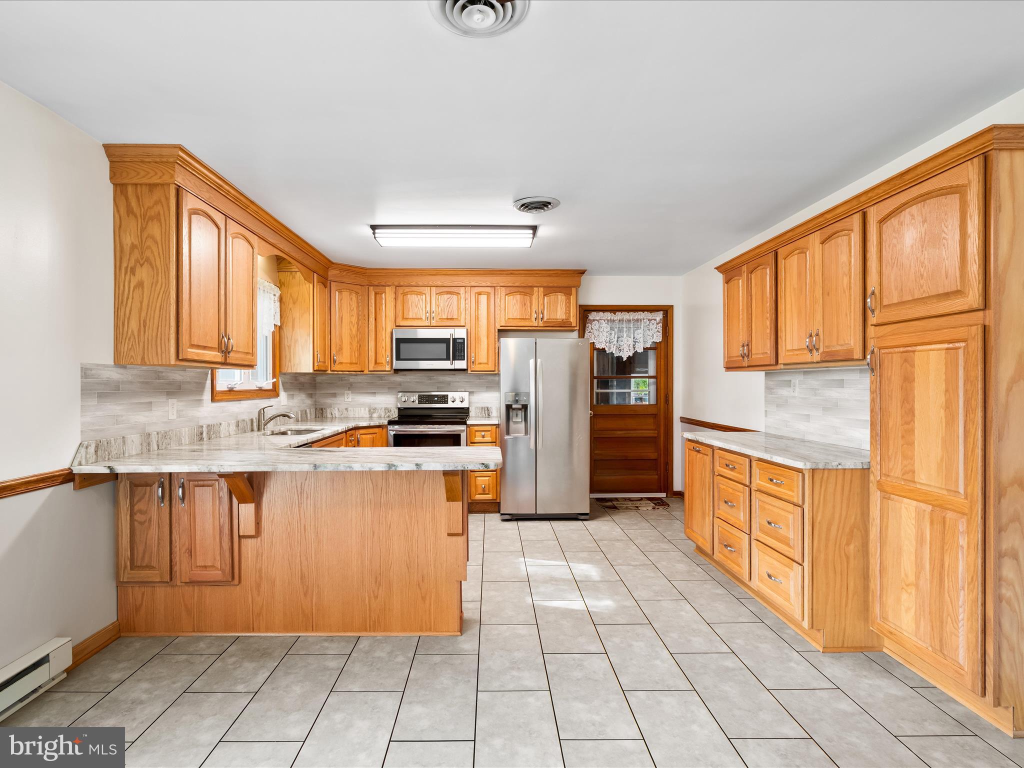 7429 Lewistown Road Thurmont, MD 21788 - Photo 23 of 68 a kitchen with stainless steel appliances granite countertop a refrigerator and wooden cabinets