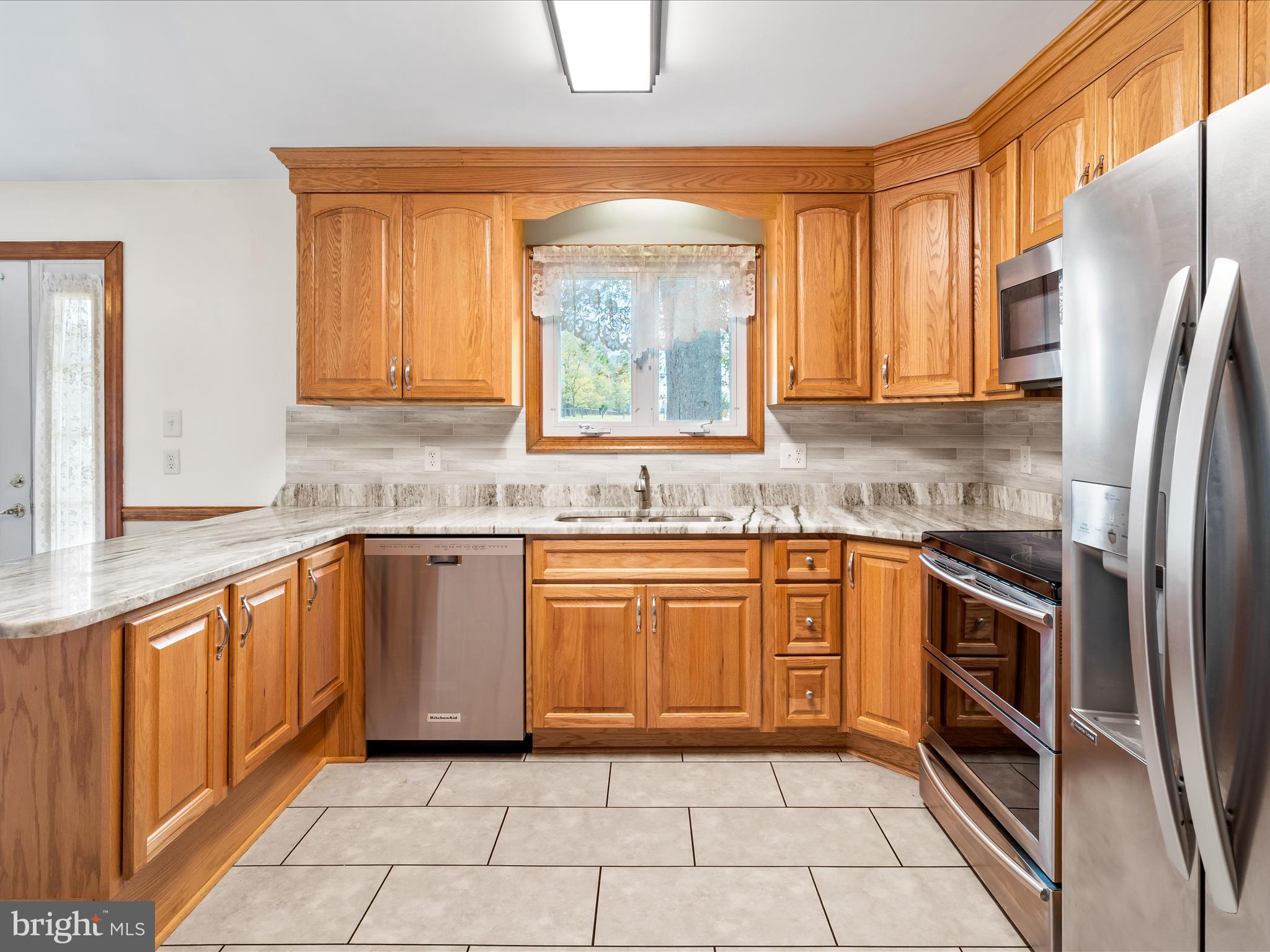 7429 Lewistown Road Thurmont, MD 21788 - Photo 24 of 68 a kitchen with stainless steel appliances granite countertop a stove a sink and a refrigerator
