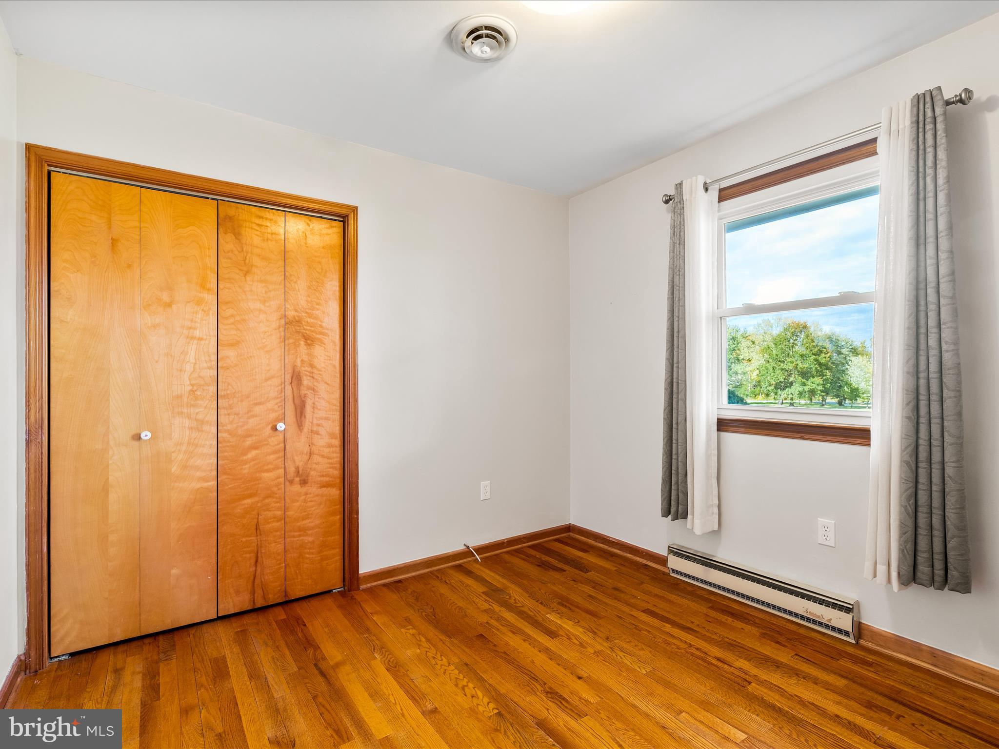 7429 Lewistown Road Thurmont, MD 21788 - Photo 33 of 68 a view of an empty room with wooden floor and a window