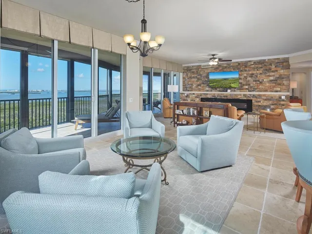 a living room with patio furniture and a chandelier