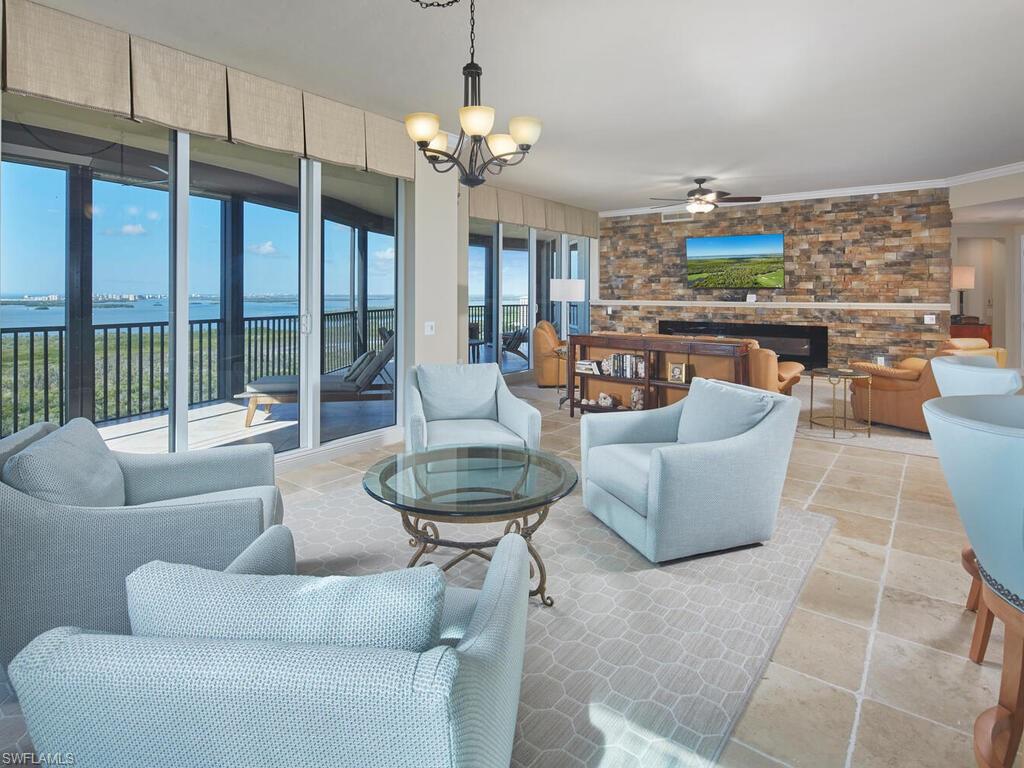 23750 Via Trevi Way, Unit 2001 Estero, FL 34134 - Photo 11 of 26 Living room with a chandelier, a water view, and ceiling fan