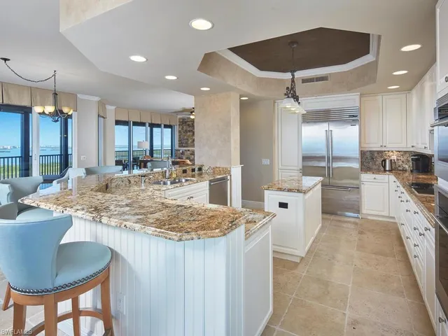 a kitchen with white cabinets and sink