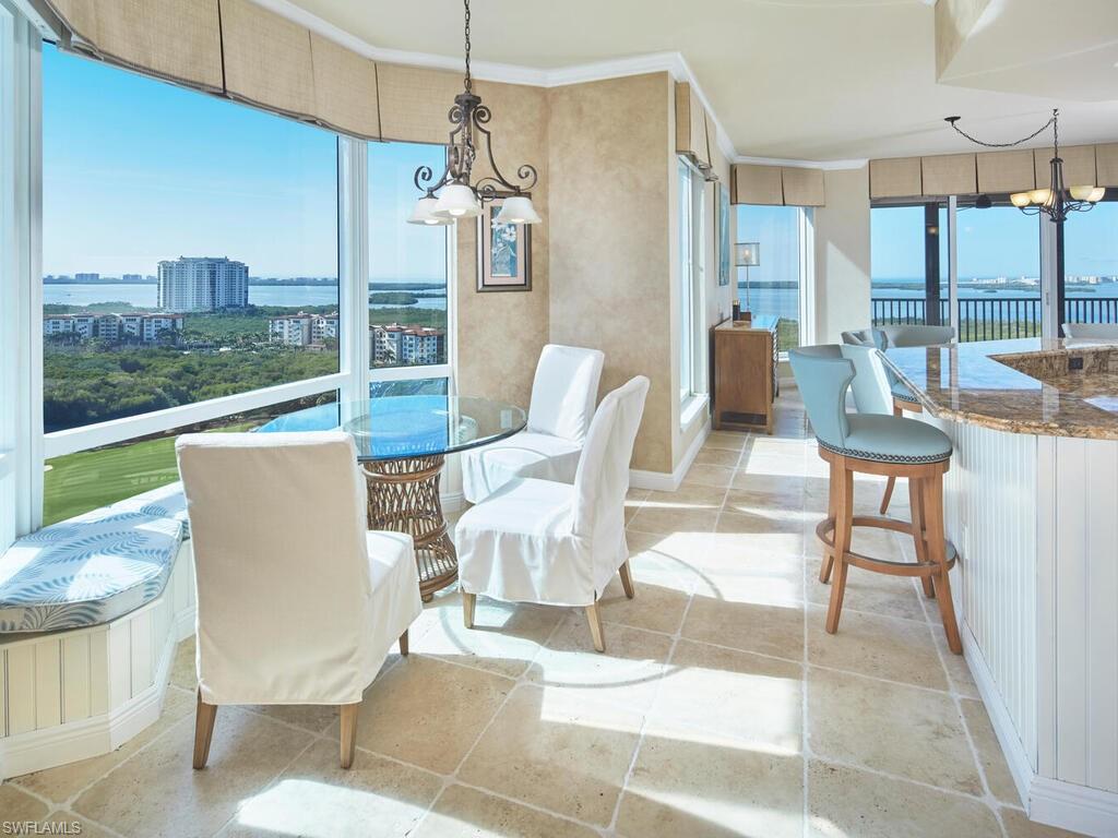 23750 Via Trevi Way, Unit 2001 Estero, FL 34134 - Photo 15 of 26 Dining space with a chandelier, a water view, light tile patterned flooring, and ornamental molding