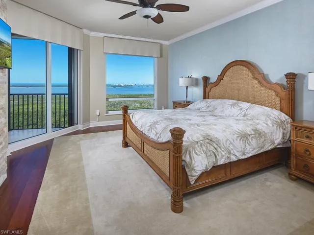 a bed sitting in a spacious bedroom next to a window
