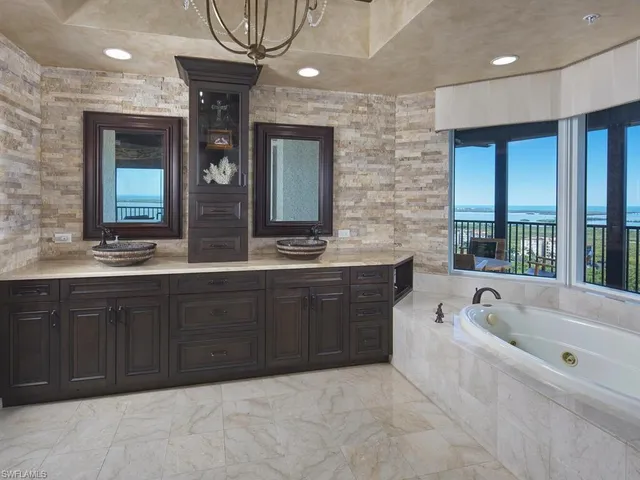 a spacious bathroom with a tub sink and mirror