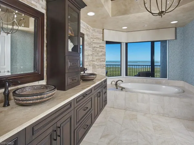 a bathroom with a granite countertop sink and a bathtub
