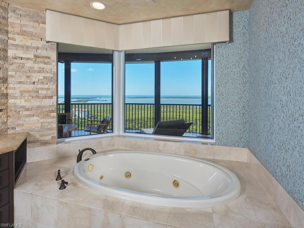 23750 Via Trevi Way, Unit 2001 Estero, FL 34134 - Photo 19 of 26 Bathroom featuring a whirlpool tub, healthy amount of natural light, wallpapered walls, and a water view