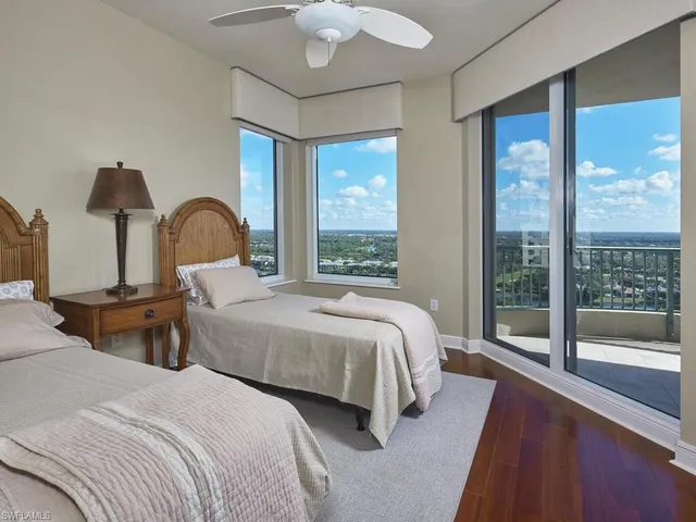 a bedroom with two beds and large window