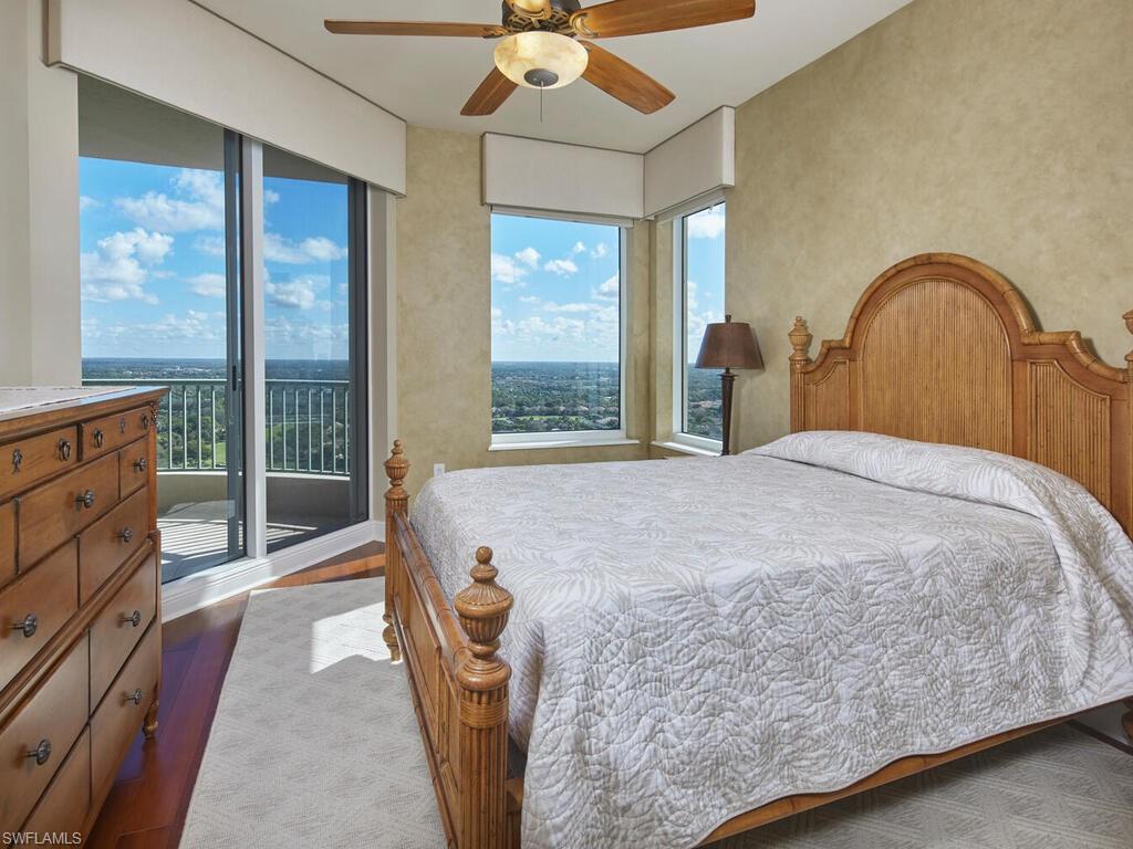 23750 Via Trevi Way, Unit 2001 Estero, FL 34134 - Photo 24 of 26 Bedroom with ceiling fan, access to exterior, and dark wood-style flooring