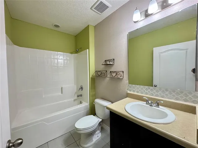 an empty room with closet and a ceiling fan