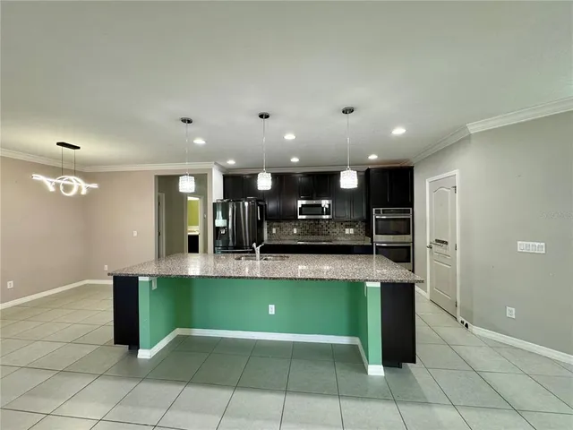a kitchen with kitchen island stainless steel appliances a sink and a counter top
