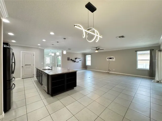 a kitchen with stainless steel appliances kitchen island granite countertop a refrigerator and stove