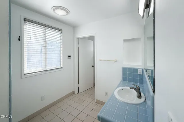 a bathroom with a granite countertop sink a toilet and a window