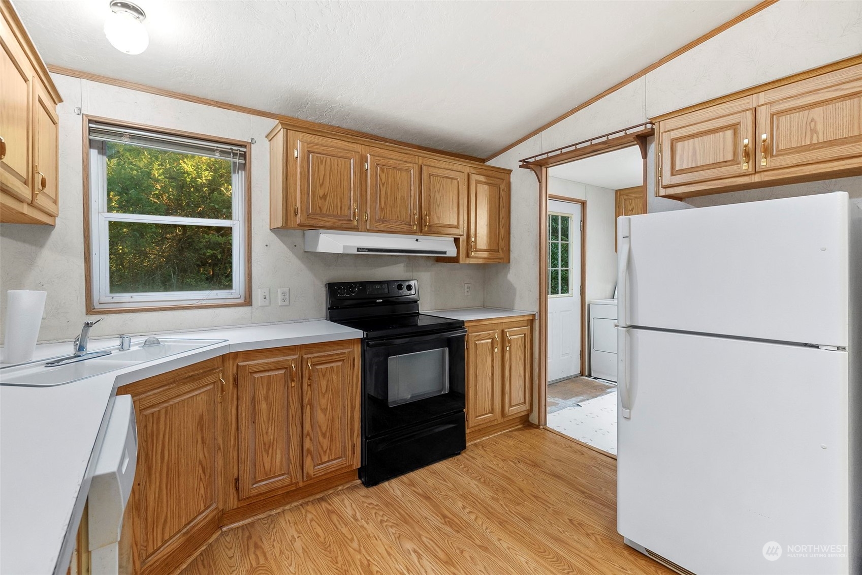 159 Heaton Road Winlock, WA 98596 - Photo 9 of 40 a kitchen with granite countertop a refrigerator a sink and white cabinets
