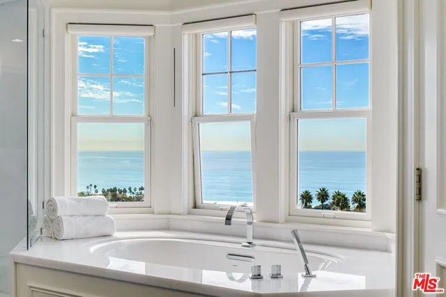 a bedroom with two beds and a large mirror with a dresser