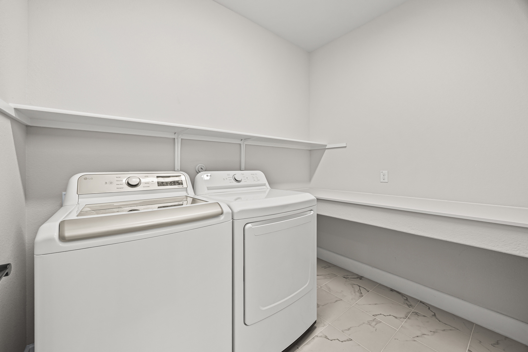 5806 Rangeland Road Austin, TX 78747 - Photo 17 of 34 Functional laundry room offers ample storage with open shelving and tiled flooring.