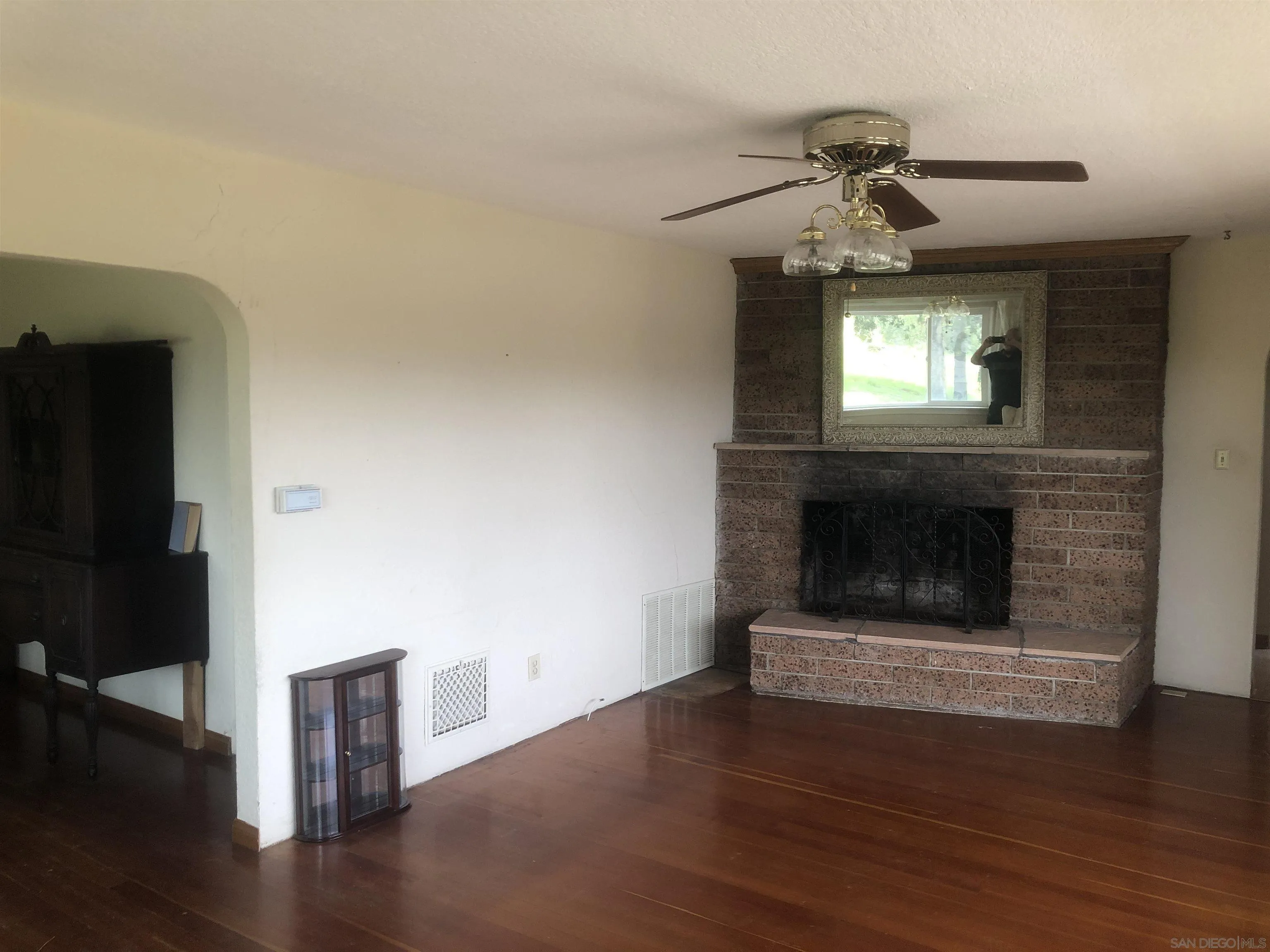 3962 Willows Road Alpine, CA 91901 - Photo 10 of 13 a living room with wooden floor and a fireplace