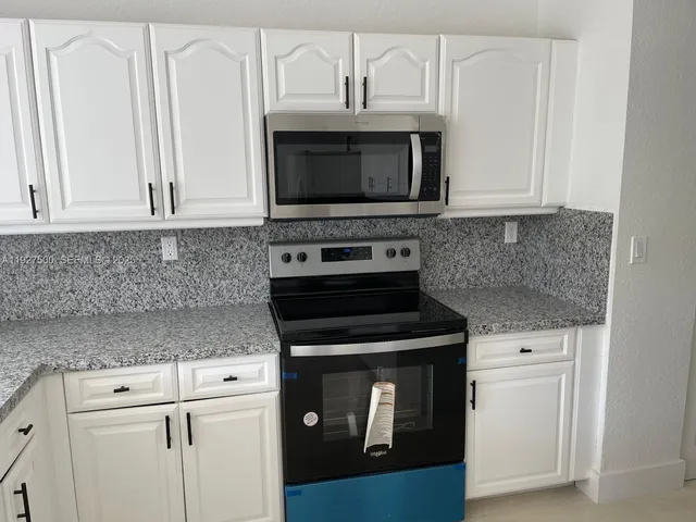 a kitchen with cabinets and stainless steel appliances