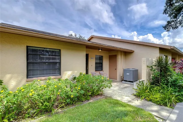 a front view of house with yard and trees in the background