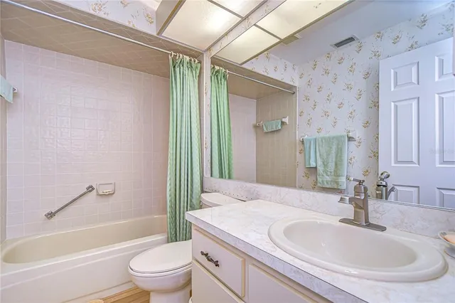 a bedroom with a bed a chandelier and dresser