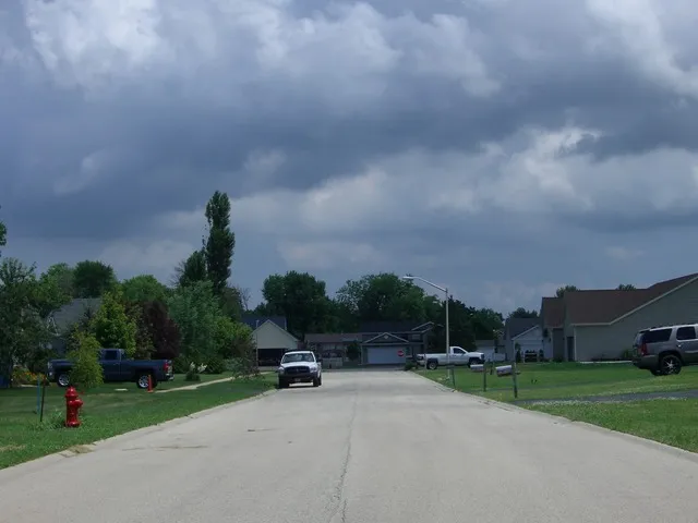 a view of a street with a building and trees in the background