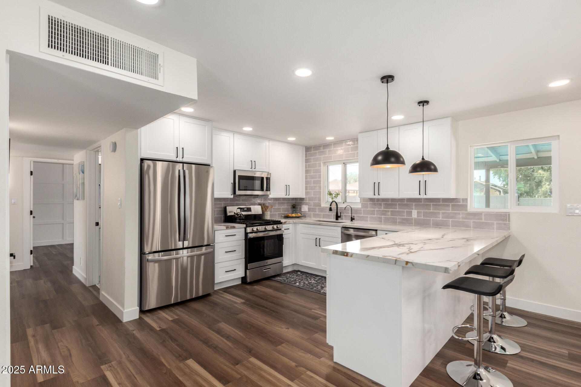1539 West 5th Street Tempe, AZ 85281 - Photo 6 of 12 a kitchen with stainless steel appliances a refrigerator a stove a sink dishwasher and a refrigerator with wooden floor