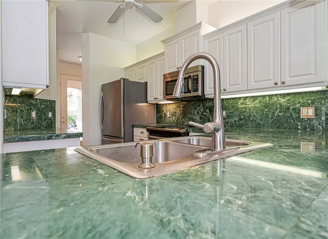 a kitchen with stainless steel appliances granite countertop a stove a sink and a microwave