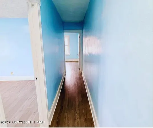 a view of a hallway with wooden floor