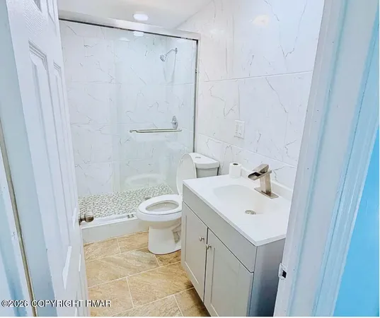 a bathroom with a sink a toilet and shower