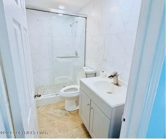 a bathroom with a sink a toilet and shower