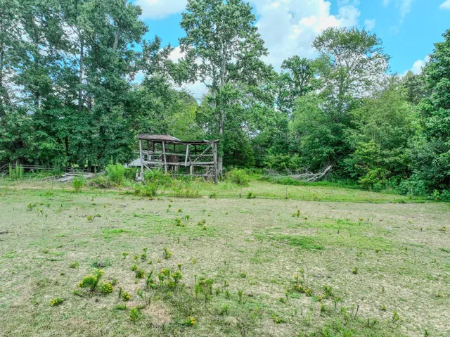 a view of a green field with wooden fence