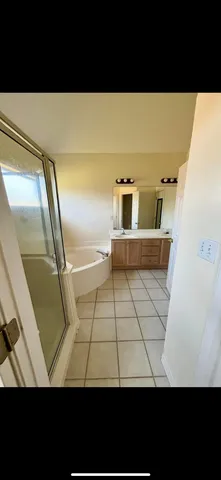 a view of an empty room with chandelier and wooden floor