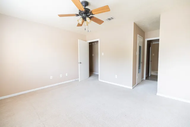 an empty room with a ceiling fan and a window