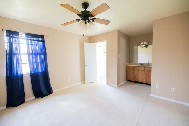 a view of a livingroom with a chandelier fan and a window