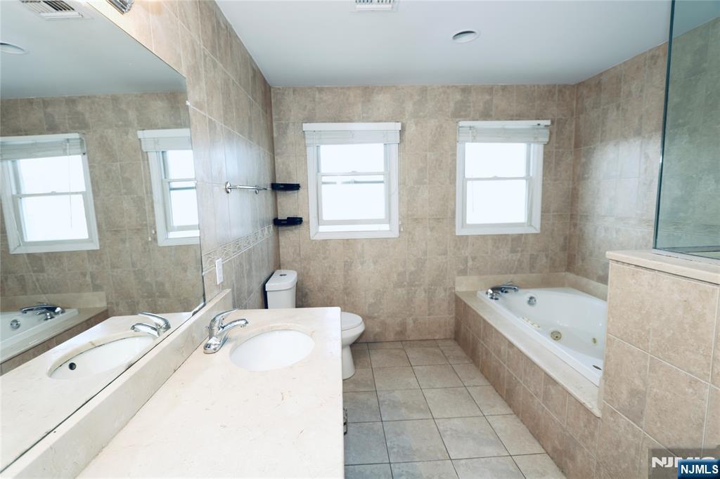 23 Main Avenue Wallington, NJ 07057 - Photo 17 of 29 a bathroom with a tub sink and mirror
