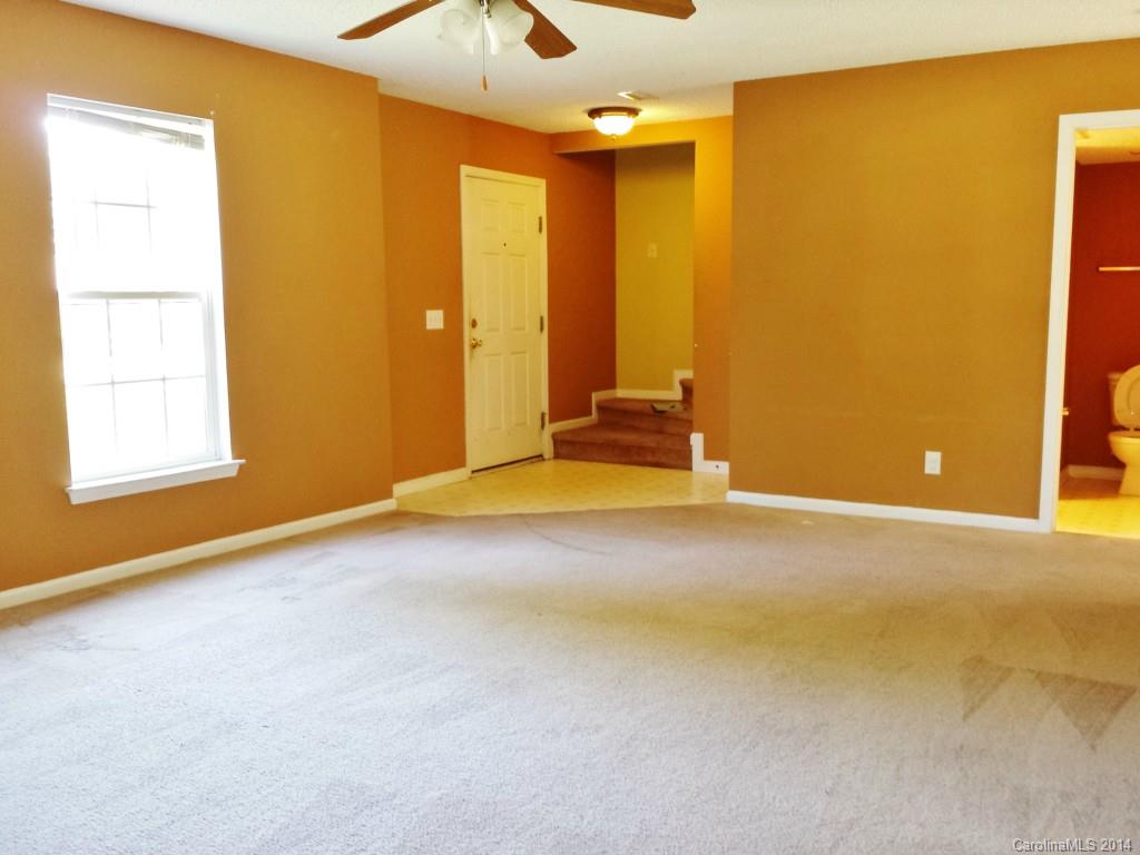 11414 Gold Pan Road Charlotte, NC 28215 - Photo 2 of 24 an empty room with windows and chandelier fan