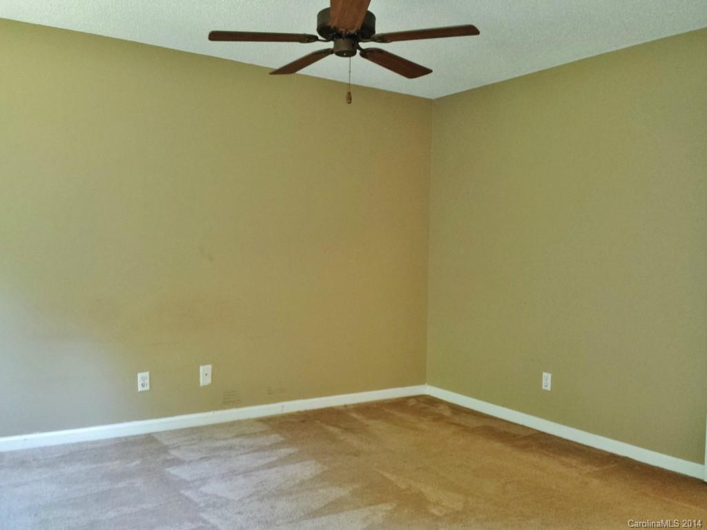 11414 Gold Pan Road Charlotte, NC 28215 - Photo 16 of 24 an empty room with a ceiling fan and carpet