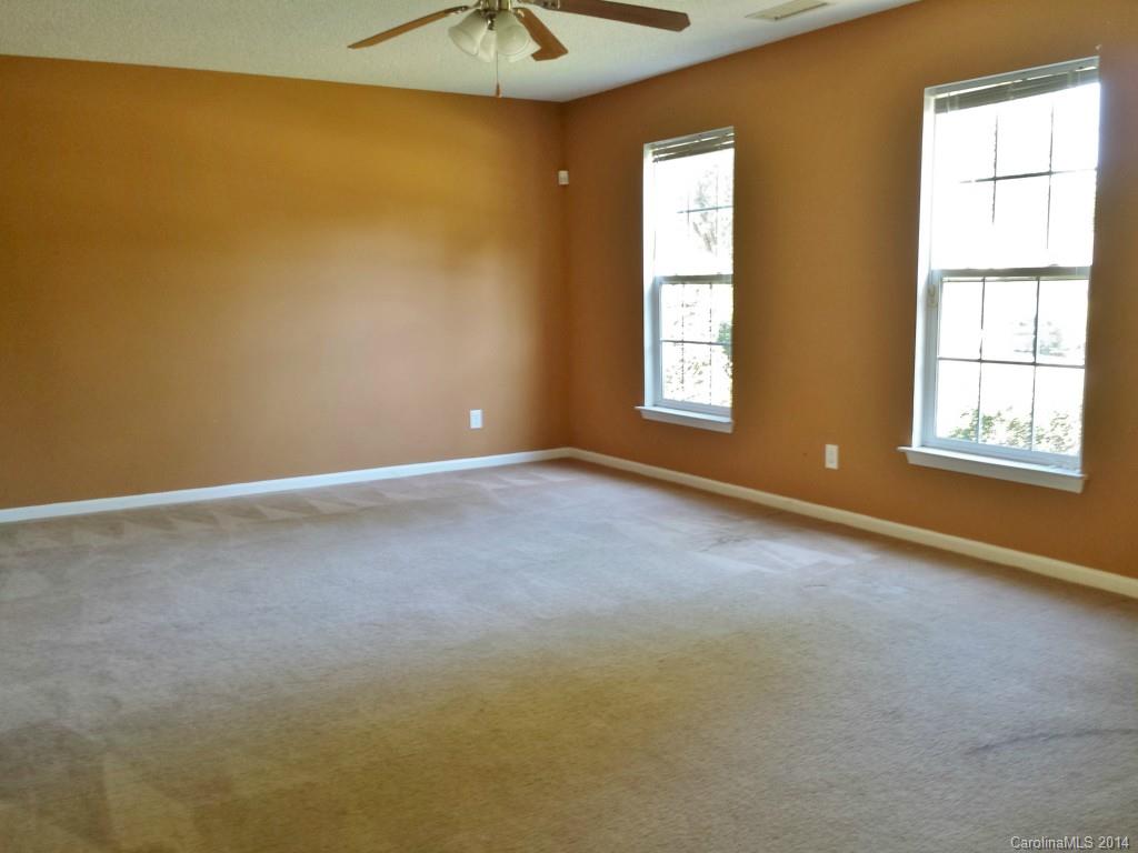 11414 Gold Pan Road Charlotte, NC 28215 - Photo 4 of 24 an empty room with windows and chandelier fan